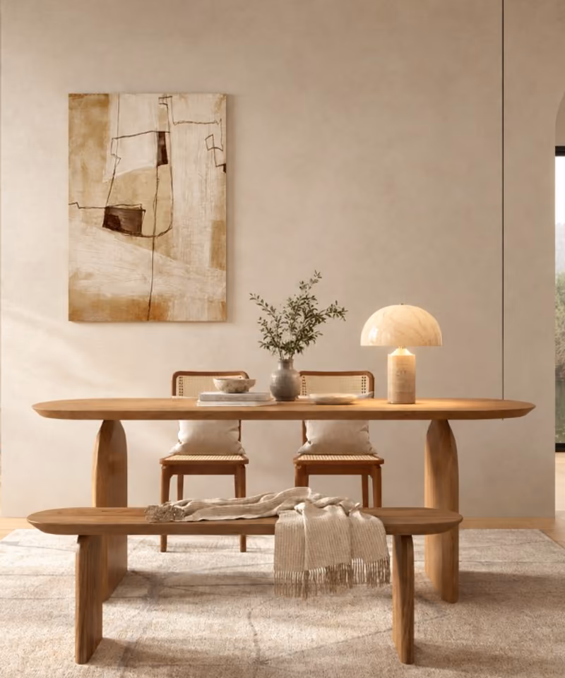 An oval wood dining table with a bench in a plaster room — Marc Tables mood